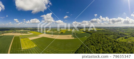 Panoramic aerial view over giant wind power field in Germany during daytime 79635347