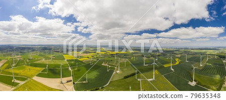 Panoramic aerial view over giant wind power field in Germany during daytime 79635348