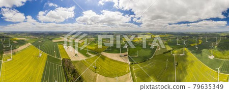 Panoramic aerial view over giant wind power field in Germany during daytime Panoramic aerial view over giant wind power field in Germany during daytime 79635349