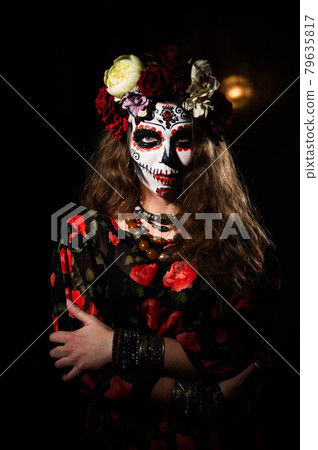 Woman in santa muerte makeup on a black background. Girl wearing traditional mexican holy death costume for halloween. Woman in santa muerte makeup on a black background. Girl wearing traditional mexican holy death costume for halloween. 79635817
