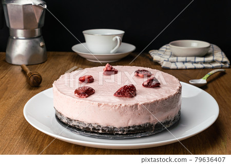 Side view of homemade delicious frozen strawberry cheesecake garnished with preserved dried strawberry in white ceramic dish. Side view of homemade delicious frozen strawberry cheesecake garnished with preserved dried strawberry in white ceramic dish. 79636407