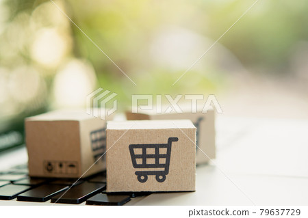 Shopping online. Cardboard box with a shopping cart logo on laptop keyboard. Shopping service on The online web. offers home delivery. copy space. 79637729