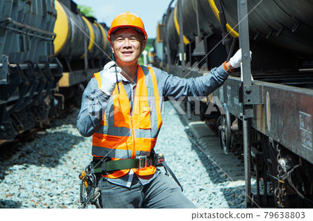 Inspector Engineering wearing helmet and vest worker unifrom checking railway construction work on rail track. Asian workers are using a walkie talkie to coordinate. Inspector Engineering wearing helmet and vest worker unifrom checking railway construction work on rail track. Asian workers are using a walkie talkie to coordinate. 79638803