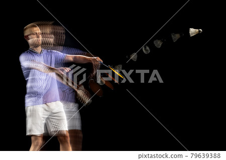 Spectacular trajectory of movement. One young male badminton player, shuttler training isolated on dark background. Stroboscope effect. 79639388