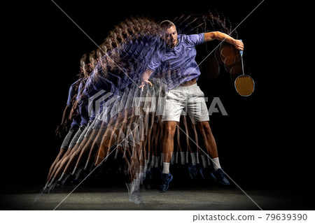 One young male badminton player, shuttler training isolated on dark background. Stroboscope effect. 79639390
