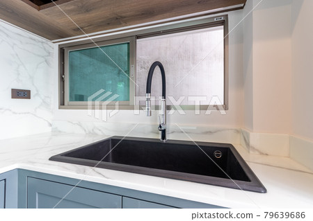 Luxurious modern black sink on a marble kitchen countertop at house 79639686