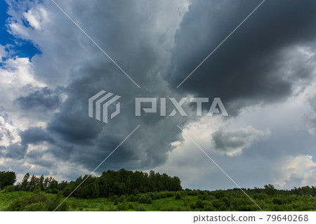 Extreme thunderstorm clouds moving over fields, climate change concept 79640268