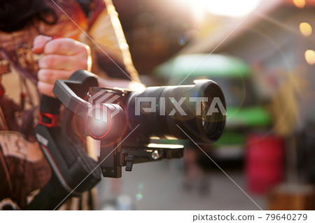 A man with a camera and a lens. Photocamera for video shooting. A man with a camera and a lens. Photocamera for video shooting. 79640279