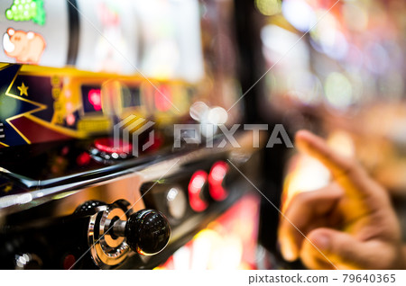 玩彈珠機老虎機的手（焦點外） 79640365