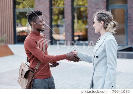 Two happy business partners or colleagues welcoming one another 79641083