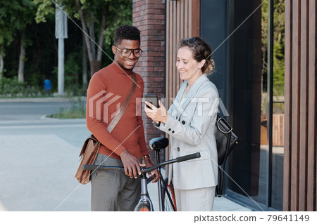 Happy businesswoman showing new mobile app to African man 79641149