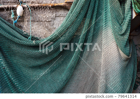Fishing net hanging on a wall for drying. 79641314