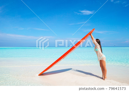 Beautiful surfer woman ready to surfing in turquoise sea, on stand up paddle board at exotic vacation Beautiful surfer woman ready to surfing in turquoise sea, on stand up paddle board at exotic vacation 79641573