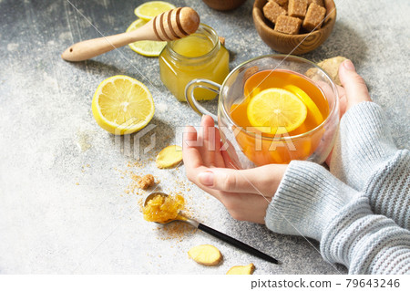 Woman holds a hot cup of ginger tea. Free space for your text. 79643246