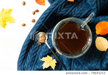 Cup of coffee with a heart shape on a warm knitted plaid background with autumn leaves. Top view flat lay background with copy space. 79643253