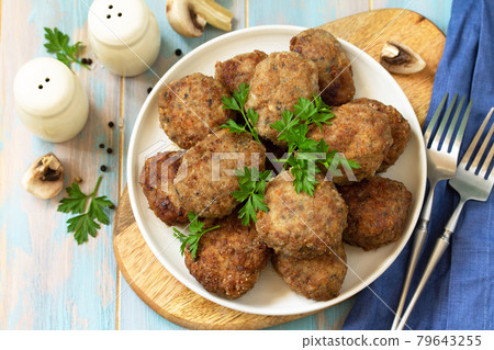 Homemade meatballs with mushrooms on the kitchen wooden table. Top view of a flat lay. 79643255