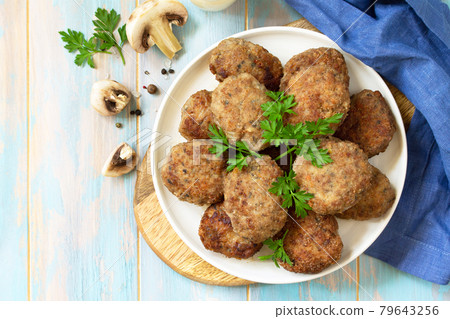Homemade meatballs with mushrooms on the kitchen wooden table. Top view of a flat lay. Copy space. Homemade meatballs with mushrooms on the kitchen wooden table. Top view of a flat lay. Copy space. 79643256