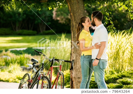 Young couple is kissing on summer nature background. 79643264
