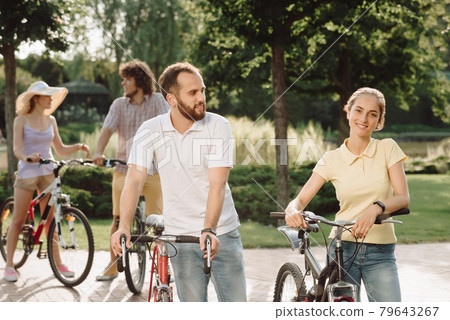 Man and woman with bicycles in park. Man and woman with bicycles in park. 79643267