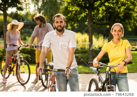 Young students with bicycles outdoors. Young students with bicycles outdoors. 79643268
