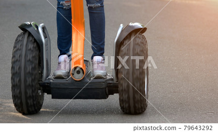 Teenage girl driving on segway outdoors. 79643292