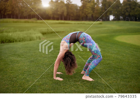 Full bridge bodyweight exercise outdoor. 79643335