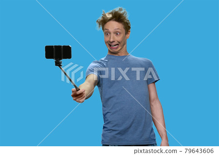 Caucasian teenage boy grimacing while making selfie. Caucasian teenage boy grimacing while making selfie. 79643606