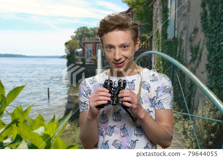 Teen boy using binoculars outdoor. Teen boy using binoculars outdoor. 79644055