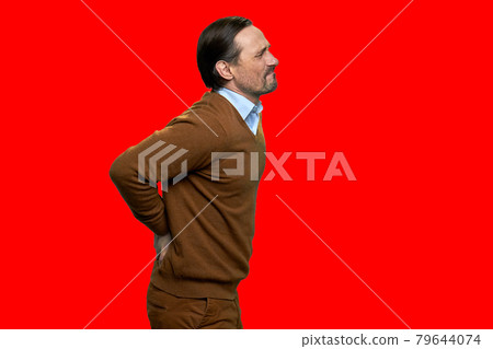 Adult man suffering from backache on red background. 79644074
