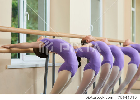 Young ballerinas stretching at ballet barre. Young ballerinas stretching at ballet barre. 79644389