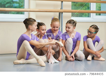 Excited young ballerinas looking on new slippers. Excited young ballerinas looking on new slippers. 79644435