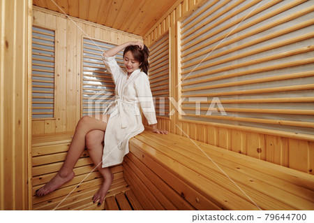Young Woman Sitting in Sauna 79644700