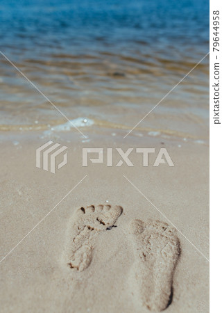 Foot prints at sand in sunrise on tropical beach 79644958
