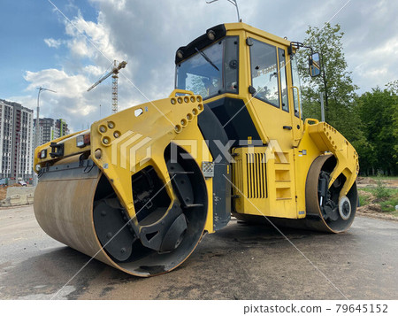 Yellow powerful large new modern road roller for asphalt paving and road repair at construction site. Construction machinery 79645152