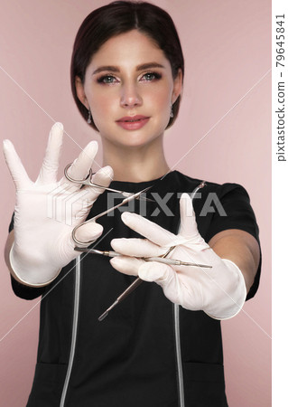 Manicurist in working form with tools in hand. Nail photo content Manicurist in working form with tools in hand. Nail photo content 79645841