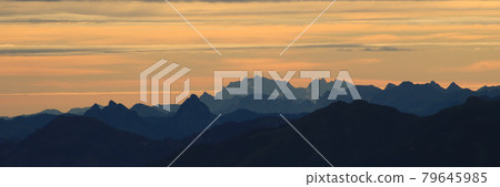 Bright lit yellow morning sky over Mount Grosser Mythen, Saentis and other mountains in the Swiss Alps. 79645985