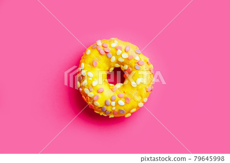 Yellow sugar glazed donut on colorful purple background. Yellow sugar glazed donut on colorful purple background. 79645998