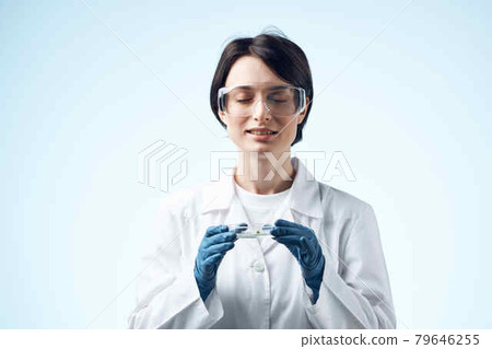 female laboratory assistant looks through a magnifying glass at a biochemical research process 79646255