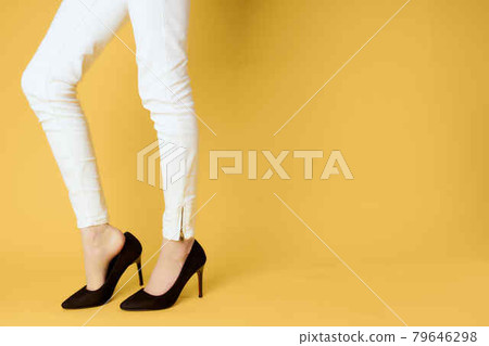 womens black shoes cropped view yellow background posing 79646298