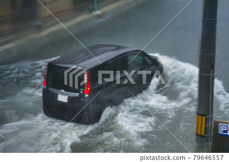 一輛汽車在被大雨淹沒的路上行駛，透過窗戶 79646557