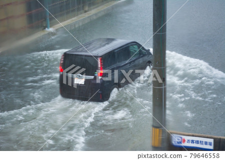 一輛汽車在被大雨淹沒的路上行駛，透過窗戶 79646558