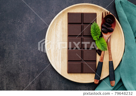 Food conceptual image with dark chocolate and fork on dark concrete background. Food conceptual image with dark chocolate and fork on dark concrete background. 79648232