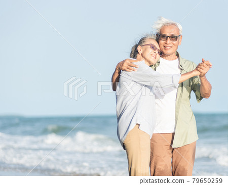Happy Asian senior man and woman couple smile dancing resting relax on the beach Happy Asian senior man and woman couple smile dancing resting relax on the beach 79650259