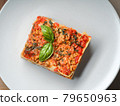 Piece of lasagna on white plate close-up. Menu of 79650963