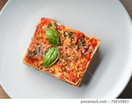 Piece of lasagna on white plate close-up. Menu of 79650963