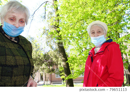 Happy positive smiling senior woman takes off protective medical mask from face outdoors Happy positive smiling senior woman takes off protective medical mask from face outdoors 79651113