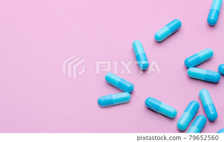 Blue antibiotic capsule pills spread on pink background. Antibiotic drug resistance. Pharmaceutical industry. Healthcare and medicine concept. Health budget concept. Capsule manufacturing industry. Blue antibiotic capsule pills spread on pink background. Antibiotic drug resistance. Pharmaceutical industry. Healthcare and medicine concept. Health budget concept. Capsule manufacturing industry. 79652560