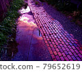 A puddle that turns purple after the rain at dusk in summer 79652619