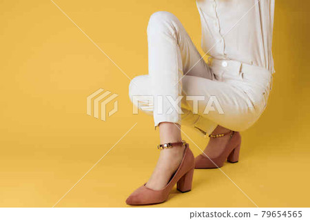 female feet fashion shoes posing close-up yellow background female feet fashion shoes posing close-up yellow background 79654565