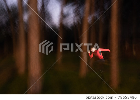 Man running through the trees on a blurred motion of forest Man running through the trees on a blurred motion of forest 79655486